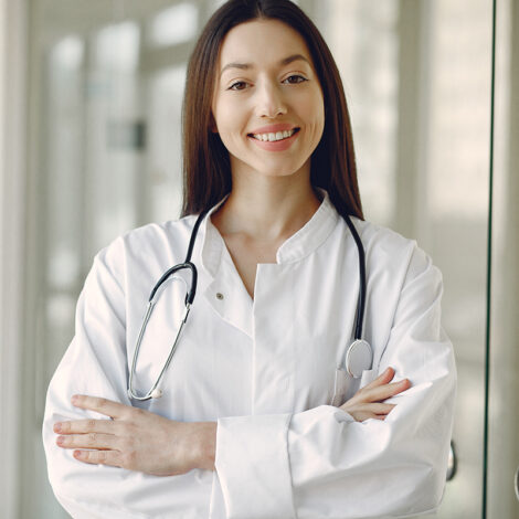 Woman in a uniform. Doctio with a stethoscope. Brunette in a hall.